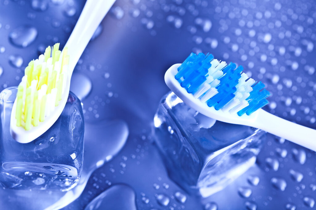 Bildet viser to tannbørster og to isbiter.