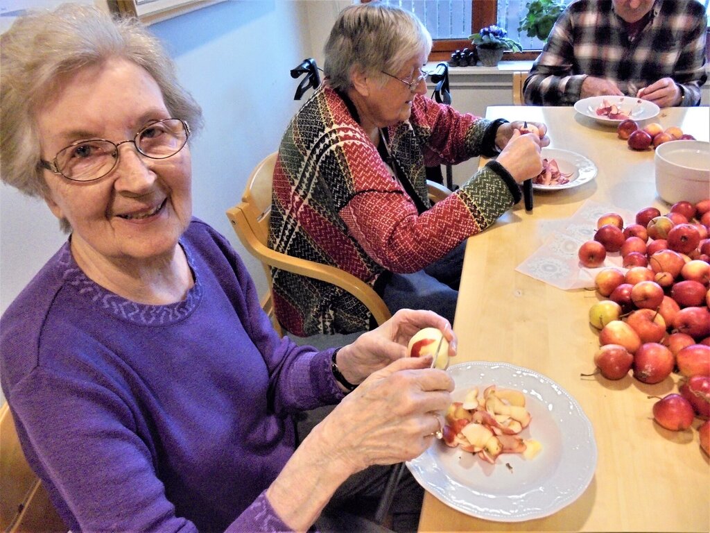 bildet viser beboere ved Åfjord helsesenter som skreller epler