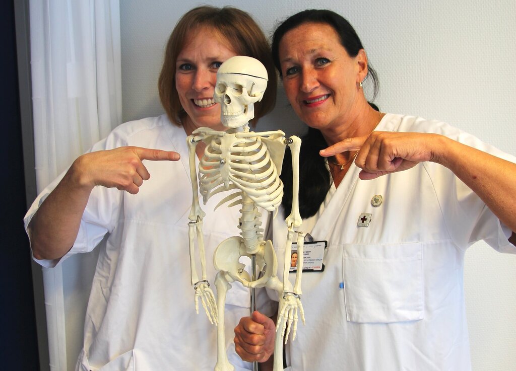 Bildet viser Hanne Louise Hoelstad og May-Britt Stenbro som holder et skjelett.