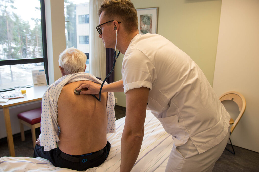 Bildet viser Jarl Robert Wexhall som lytter på en pasient med stetoskop.