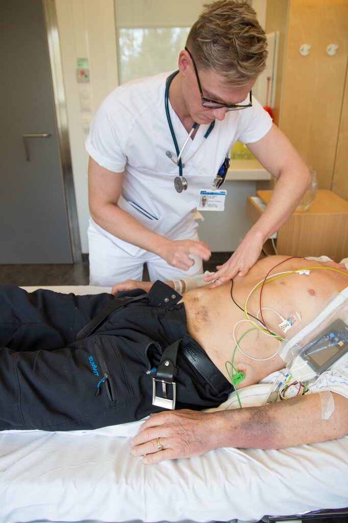 Bildet viser Jarl Robert Wexhall som perkuterer magen til en pasient.