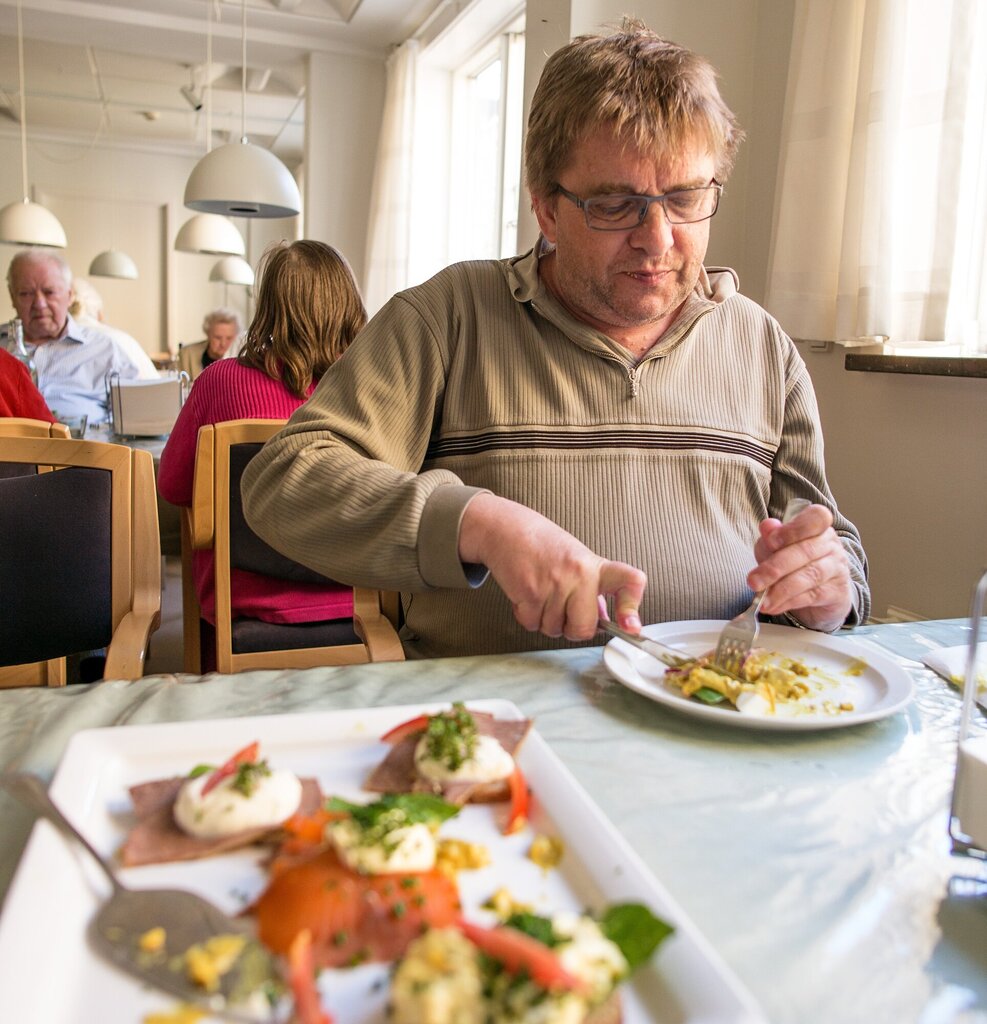 Bildet viser Niels Hansen som sitter og spiser.
