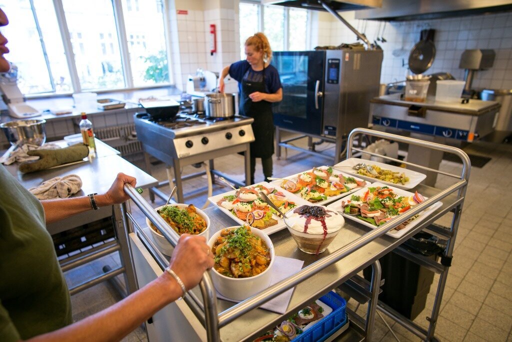Bildet viser kokker som lager i stand til måltid på Rundskuedagens plejecenter i København.