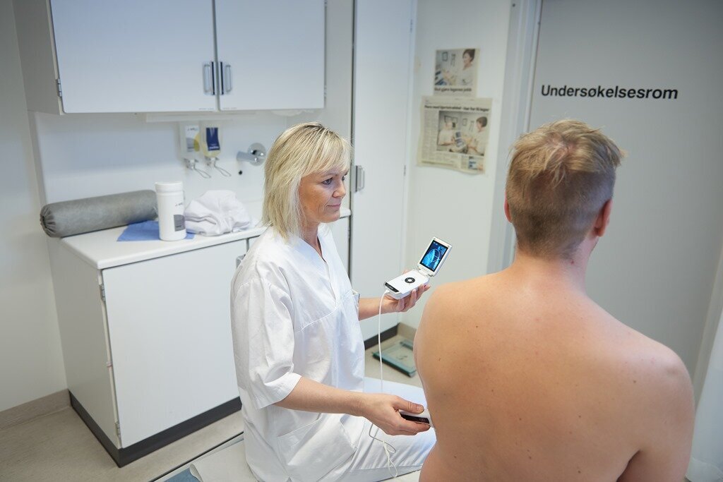 Sykepleier Guri H. Gundersen tar ultralyd på en mannlig pasient.