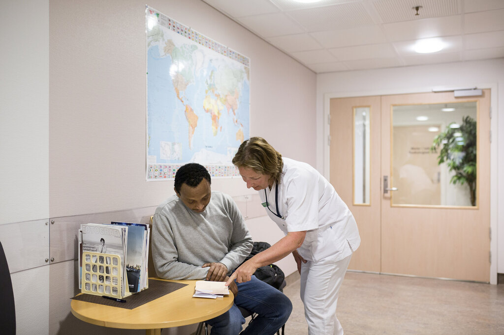 Bildet viser en sykepleier og en pasient på et venterom på en poliklinisk avdeling på Haukeland universitetssjukehus