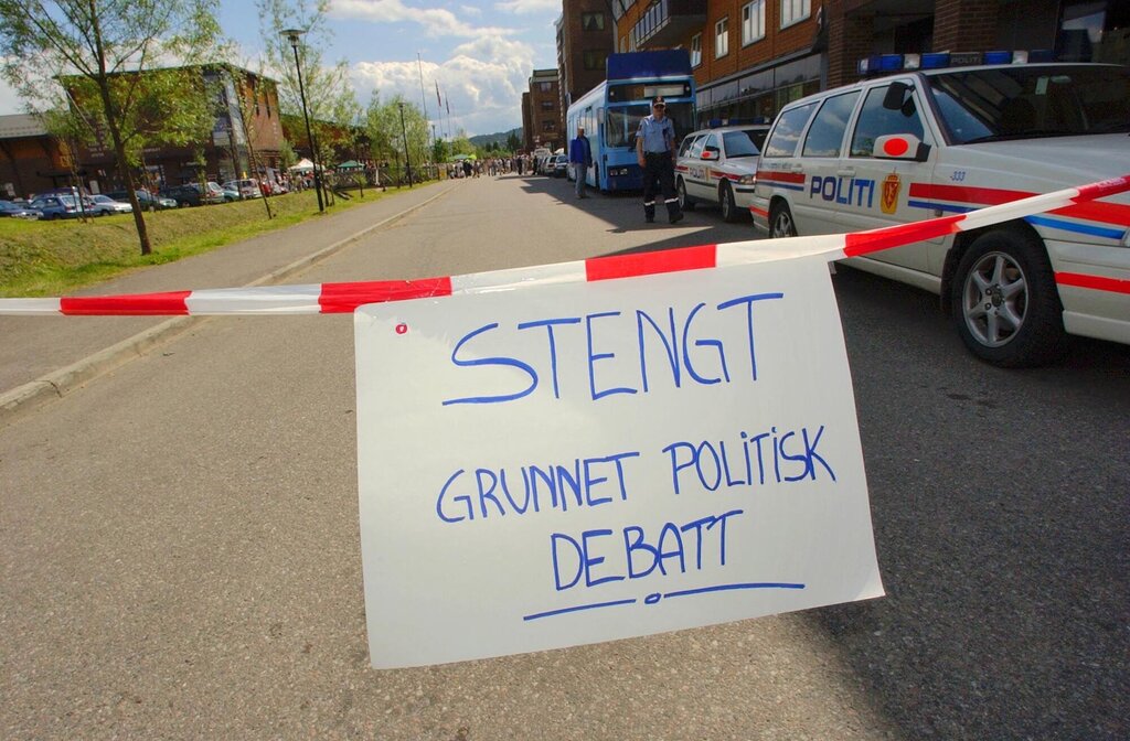 Bildet viser en avsperret vei med et skilt hvor det står "Stengt på grunn av politisk debatt"