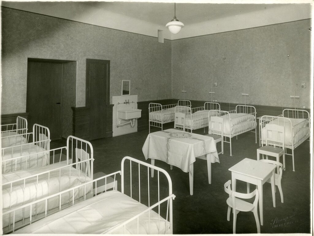 Bildet viser en sykehussal med flere senger.
