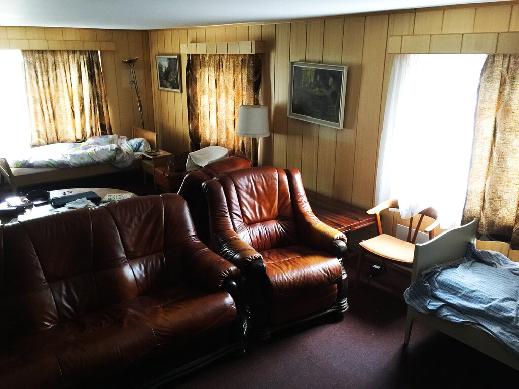 Bildet viser en stue med to oppredde senger