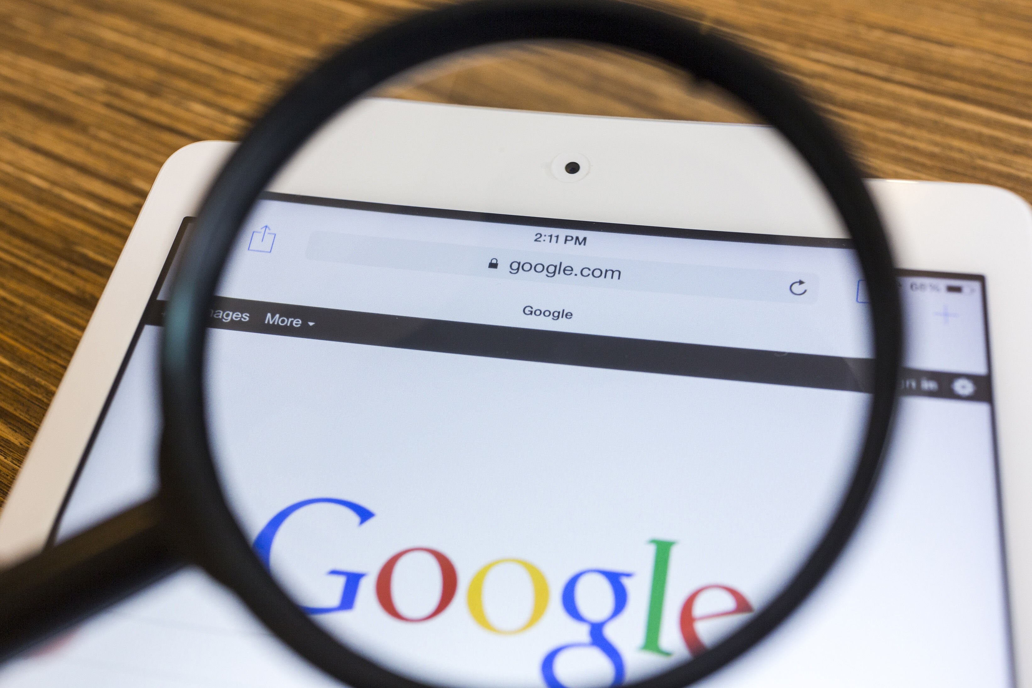 Google-søk Bildet viser et forstørrelsesglass som holdes over Googles søkeside