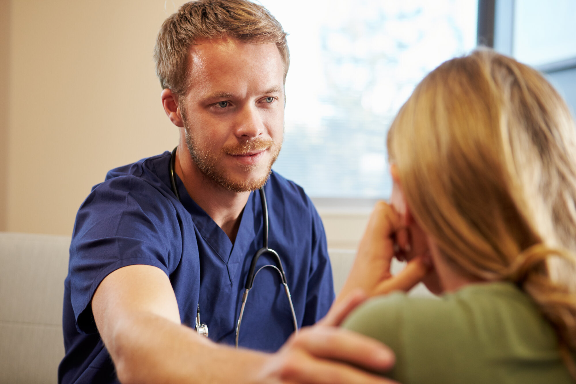 Mannlig sykepleier og kvinne. Sykepleieren viser medfølelse. Mannlig sykepleier og kvinne. Sykepleieren viser medfølelse.