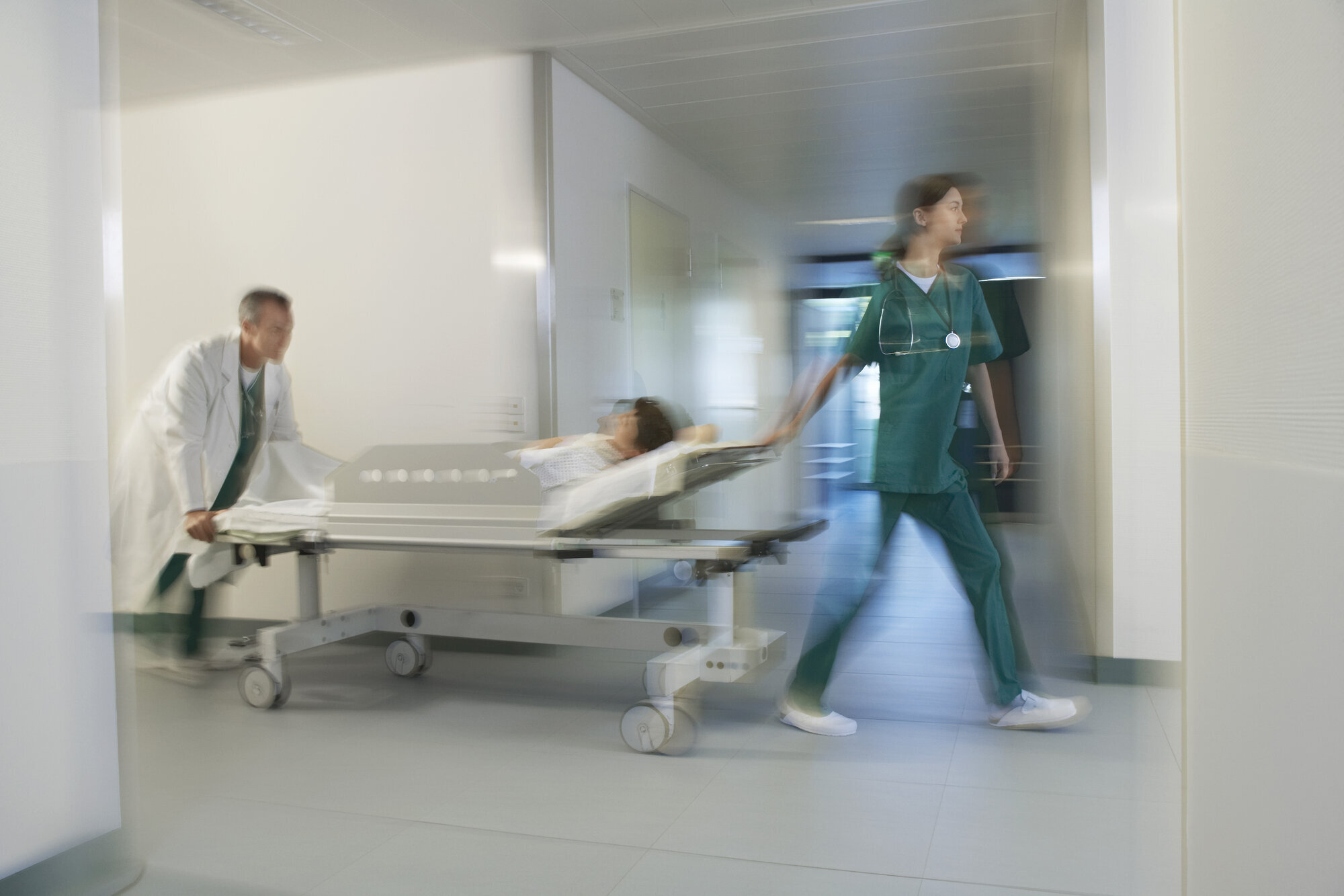 Lege og sykepleier Bildet viser en lege og en sykepleier som triller en pasient