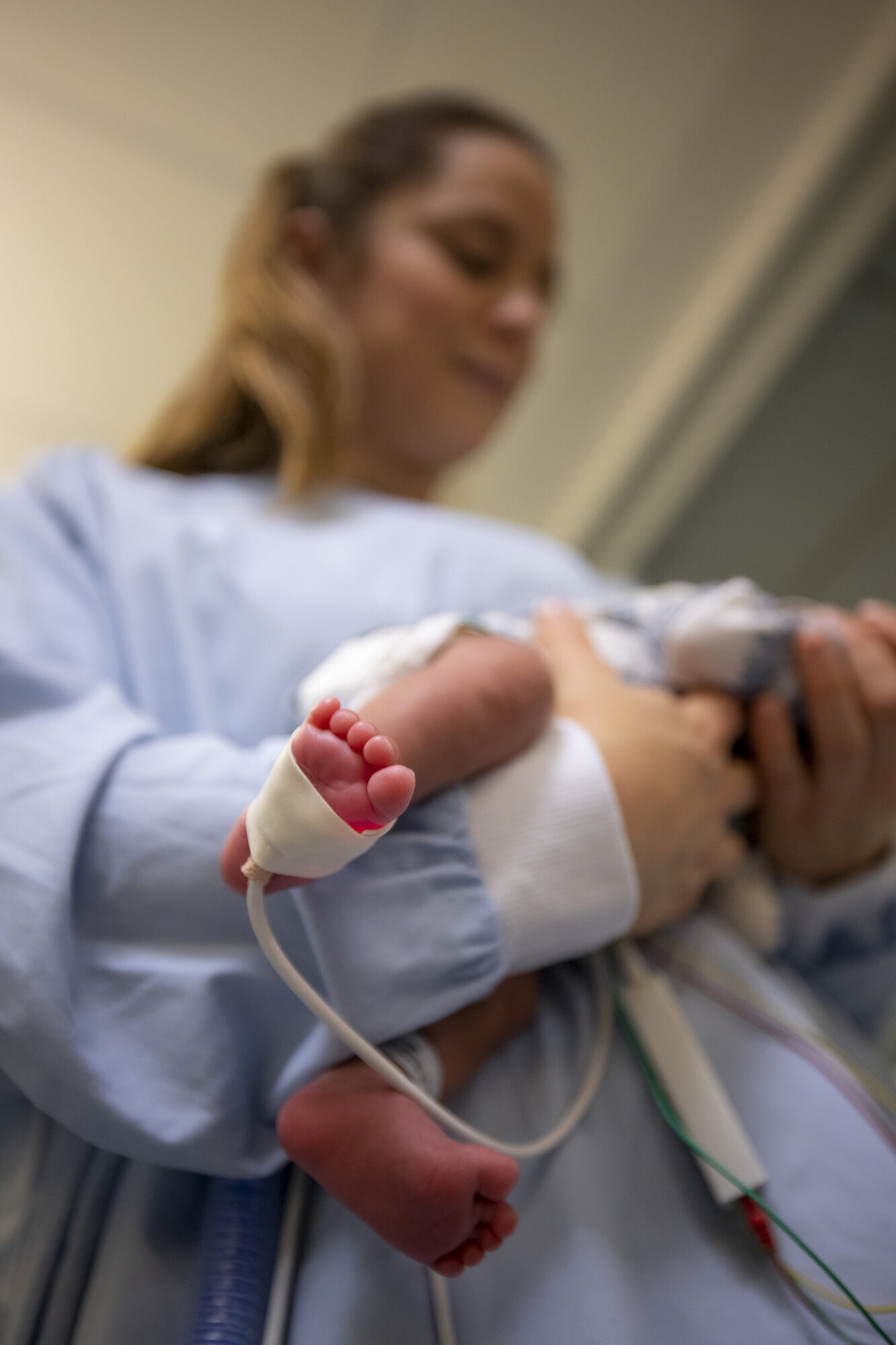 Julie Dahle Bildet viser Julie Dahle som holder en liten baby, med oksygenmetningsmåler på foten.