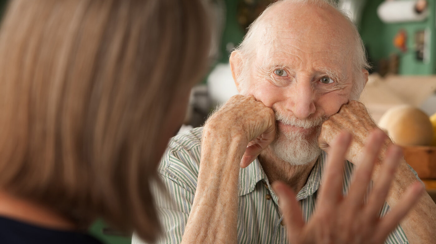 Bildet viser en eldre mann som studerer en kvinne som prater til ham.