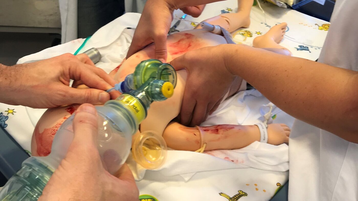 Bildet viser studenter som simulerer livreddende førstehjelp av et nyfødt barn