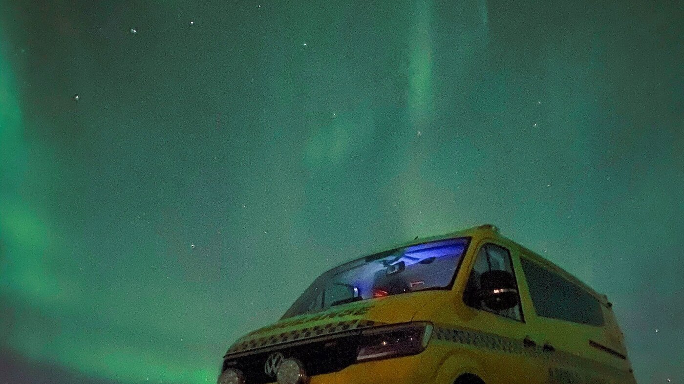 Bildet viser en ambulanse i nordlyset.