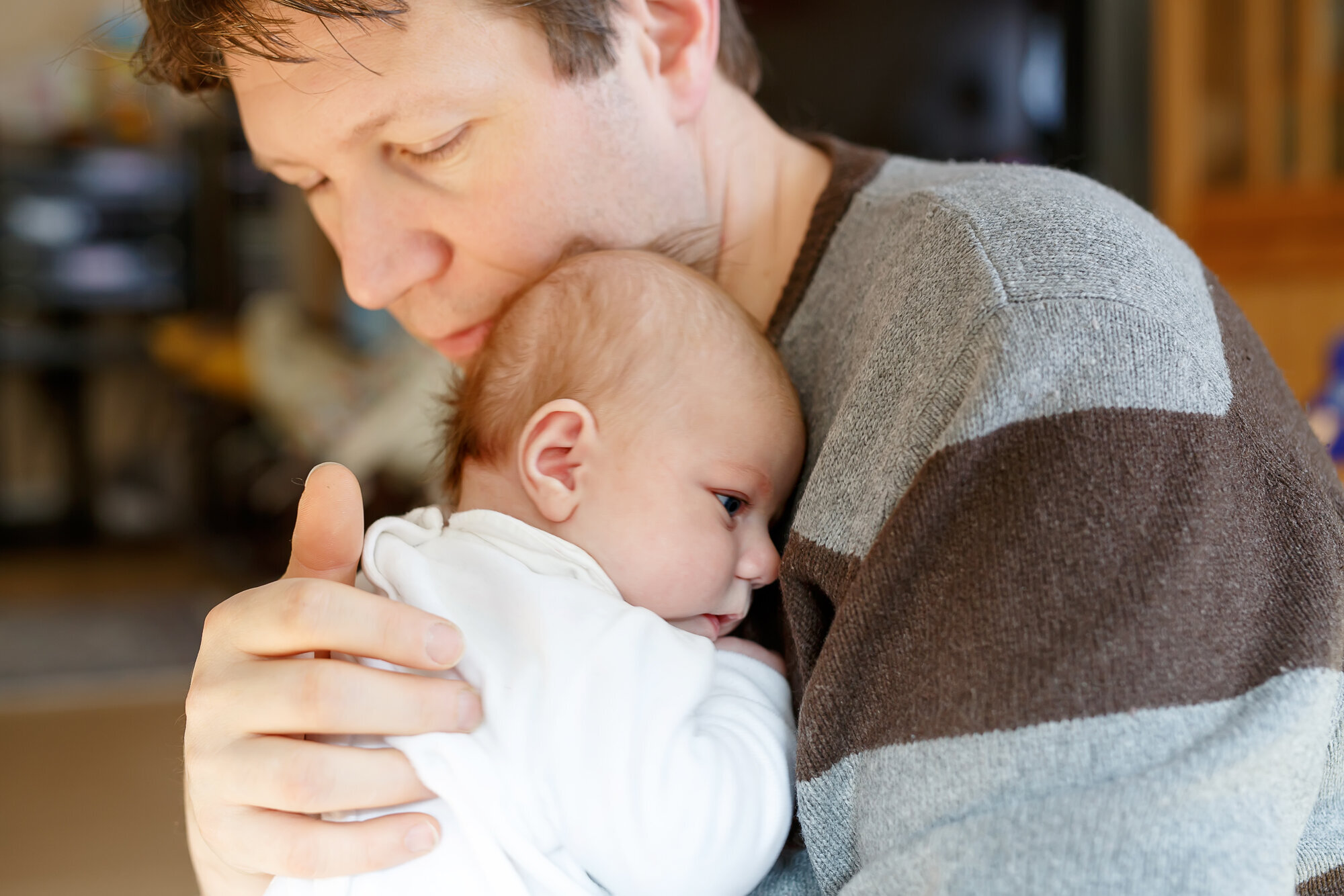 En far og en nyfødt baby Bildet viser en far og en nyfødt baby