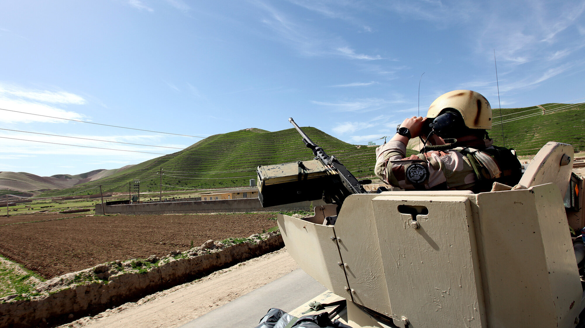 Norsk soldat i internasjonal militær operasjon Bildet viser en tanks i Afghanistan. En norsk soldat står med kikkert opp av hullet i tanksen.