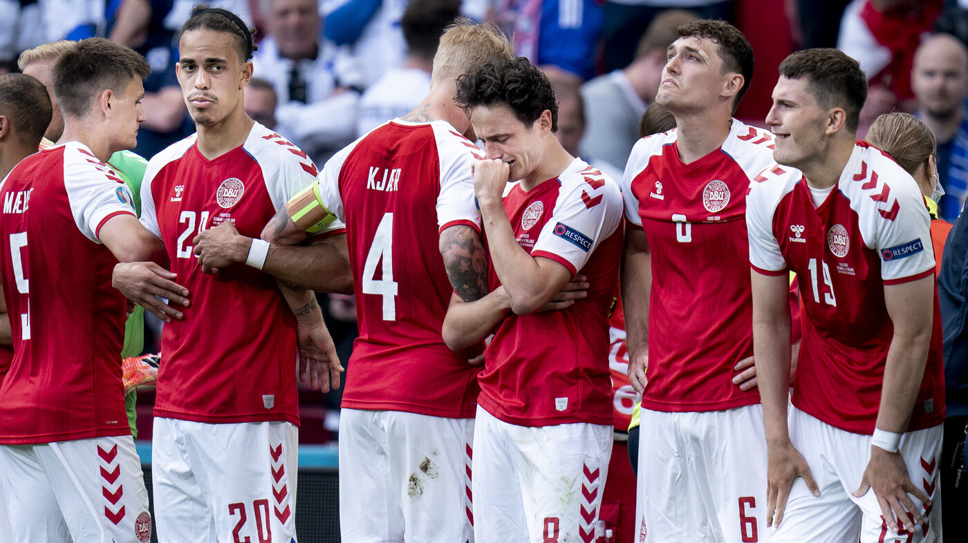 Bildet viser EM landskamp mellom Danmark og Finland12. juni 2021. Fotballspiller Christian Eriksen får livreddende behandling mens lagkamerater står rundt ham.