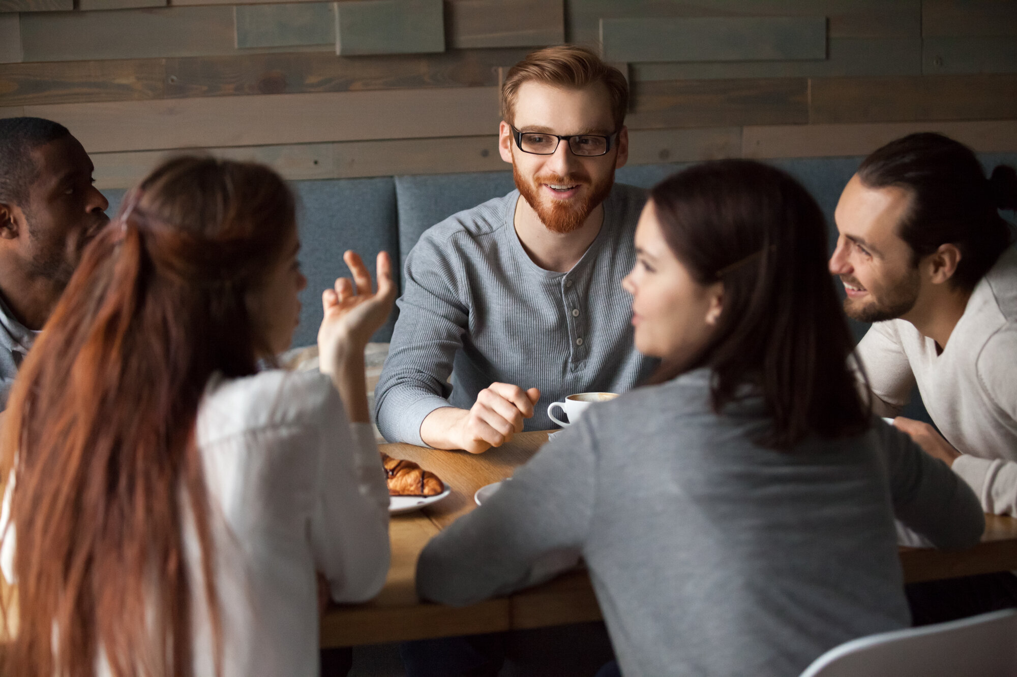 Samtale på kafé Bildet viser en gruppe unge mennesker som snakker sammen på en kafé