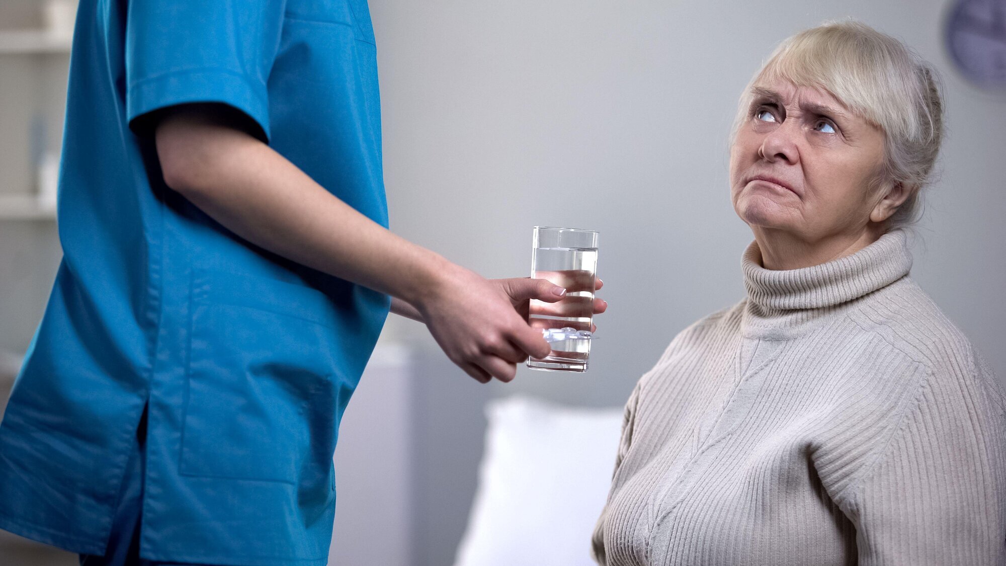 En sykepleier gir medisiner til en person med demens En sykepleier gir medisiner til en person med demens