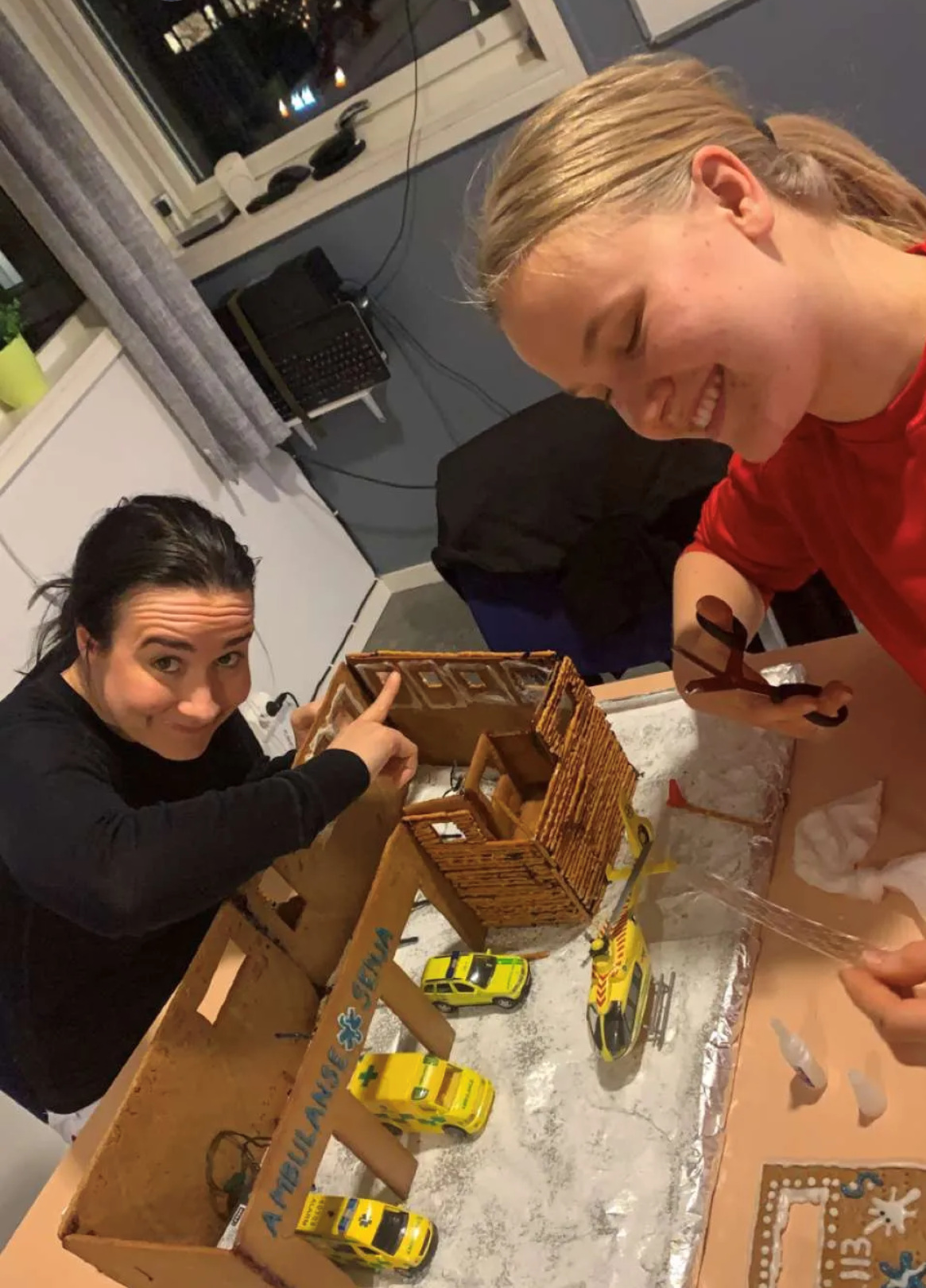 Ambulansestasjon, Finnsnes Bildet viser Ailin Waage og Live Sofie Grytnes som pynter pepperkakestasjonen.