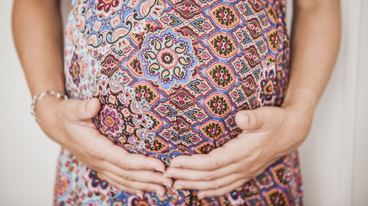 Bildet viser en gravid kvinne som holder på magen sin En gravid kvinne holder på magen sin