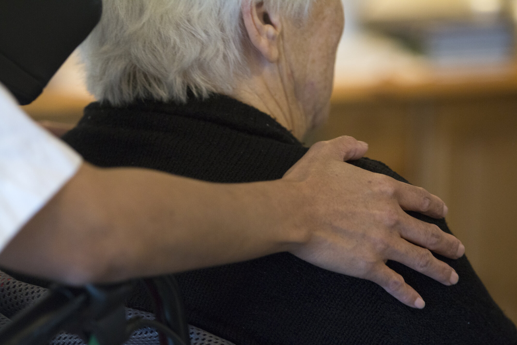 Eldre kvinne og sykepleier En sykepleier holder rundt en eldre kvinne
