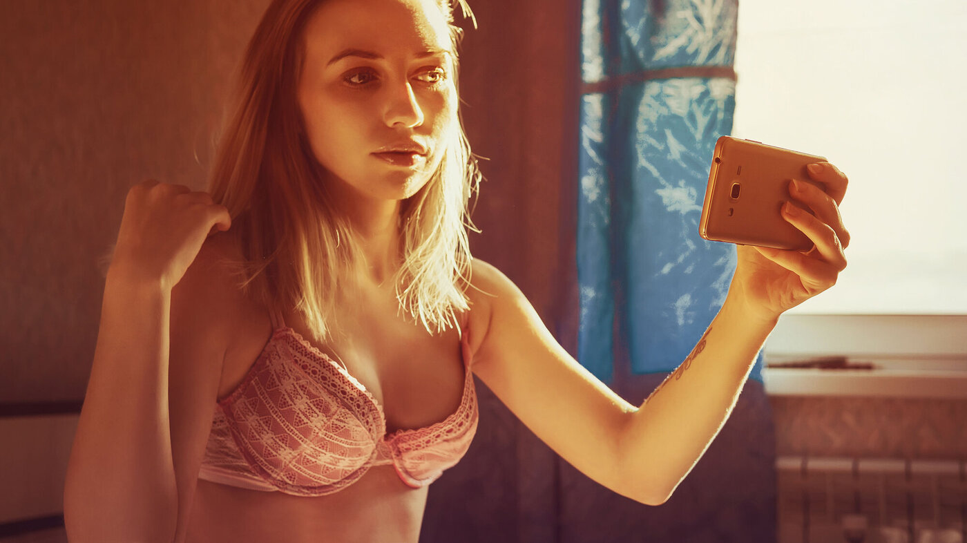 Bildet viser ei ung jente som tar selfie i bh