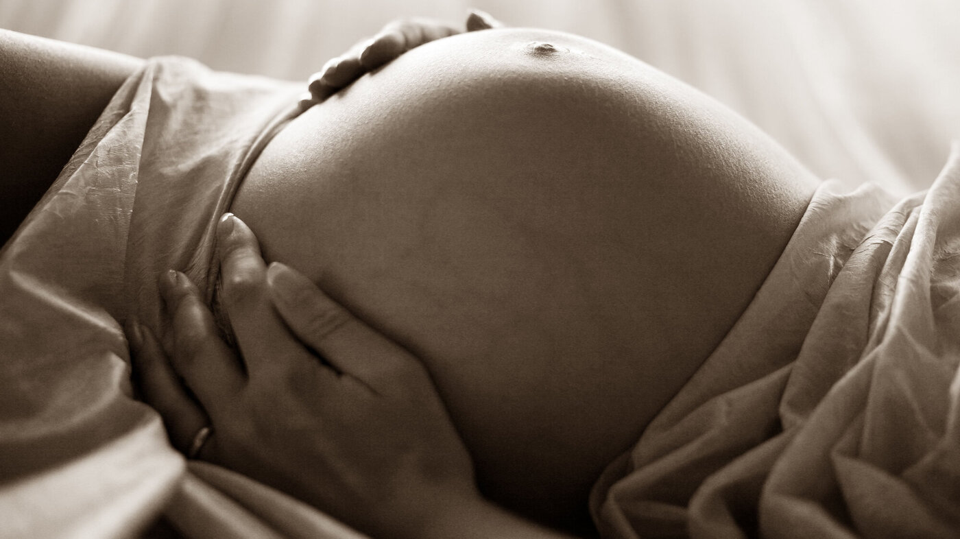 Sort/hvit bilde av en gravid mage