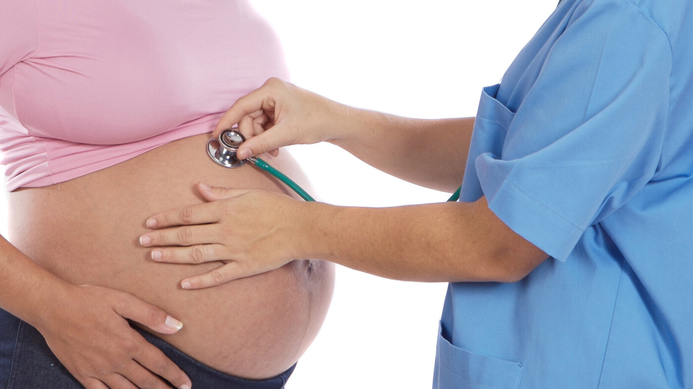 En god hjemmebasert barselomsorg er helt avhengig av økte jordmorressurser, skriver leder i Jordmorforbundet NSF. Bildet viser lytting med stetoskop mot høygravid mage.