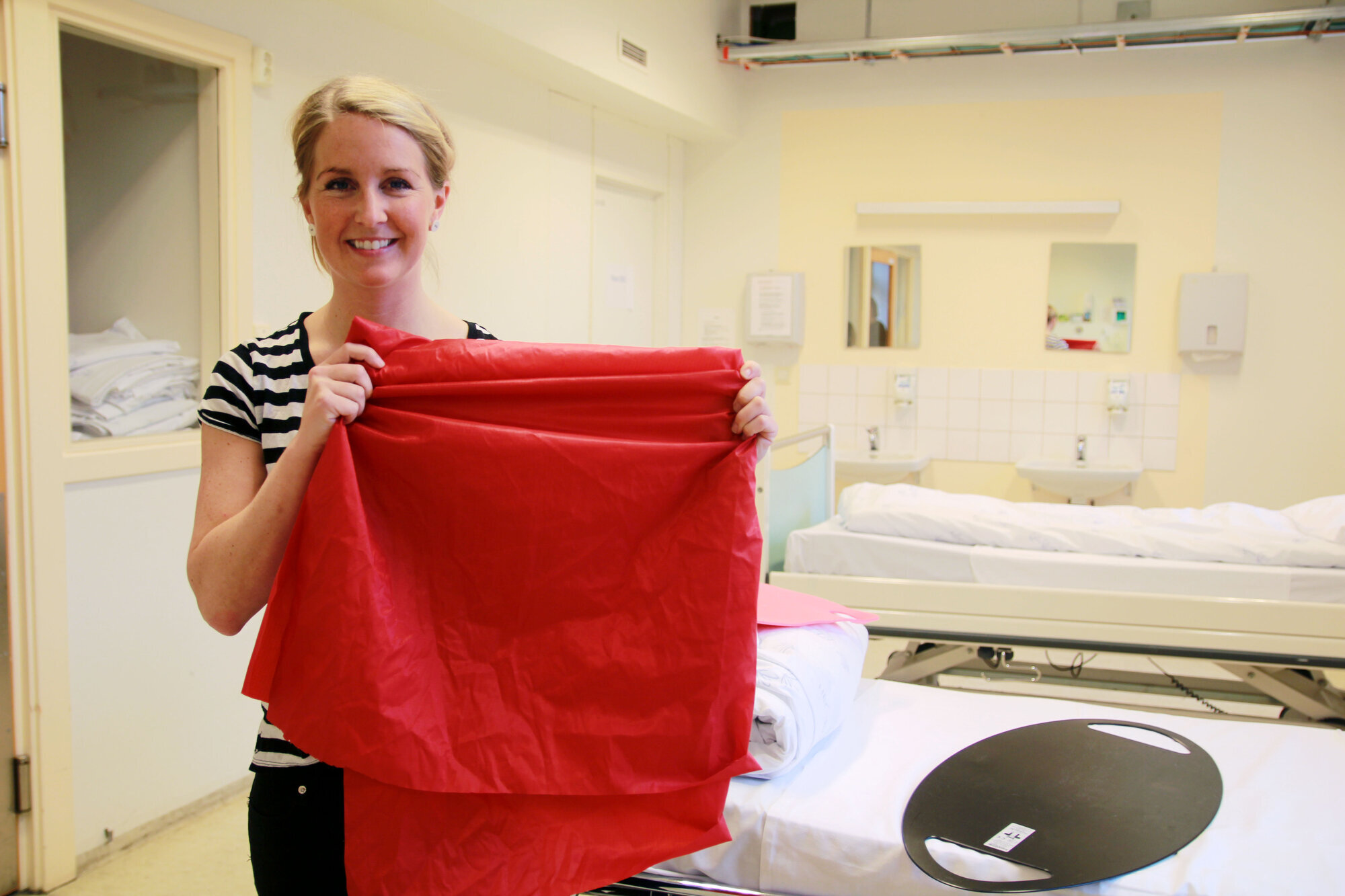 Bedriftsfysioterapeut Anne Aschehoug Loftu som viser frem en forflytningsduk. Bildet viser bedriftsfysioterapeut Anne Aschehoug Loftu som viser frem en forflytningsduk.
