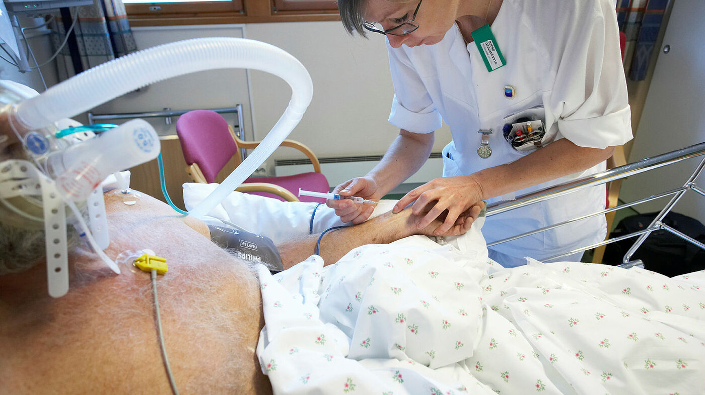 Bildet viser en sykepleier som setter sprøyte på en pasient, ved intensivavdelingen på Moss sykehus