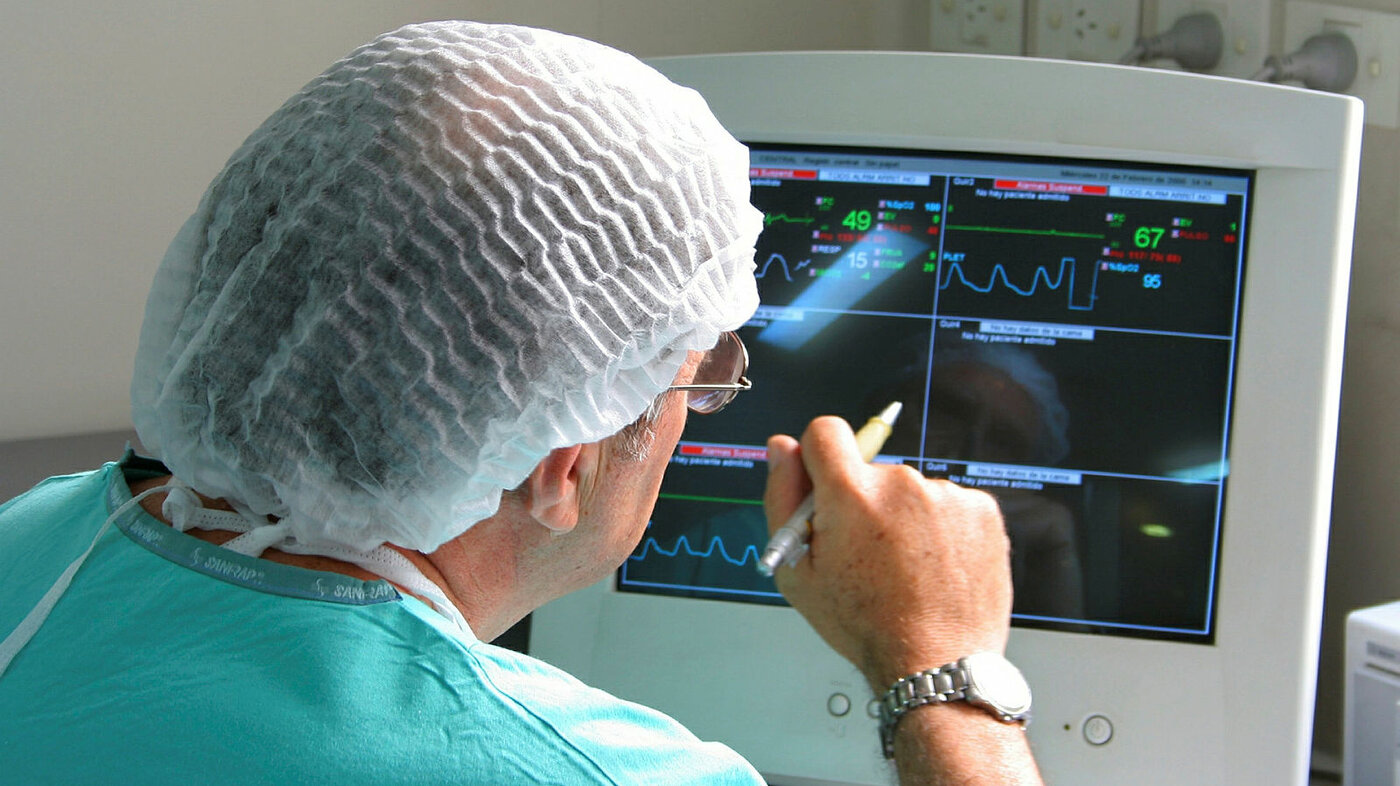 En kirurg sitter og vurderer pasientdata på en dataskjerm