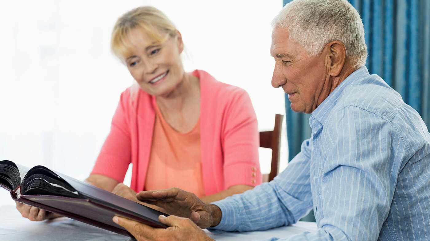 Senior couple looking at photo album Senior couple looking at photo album in a retirement home