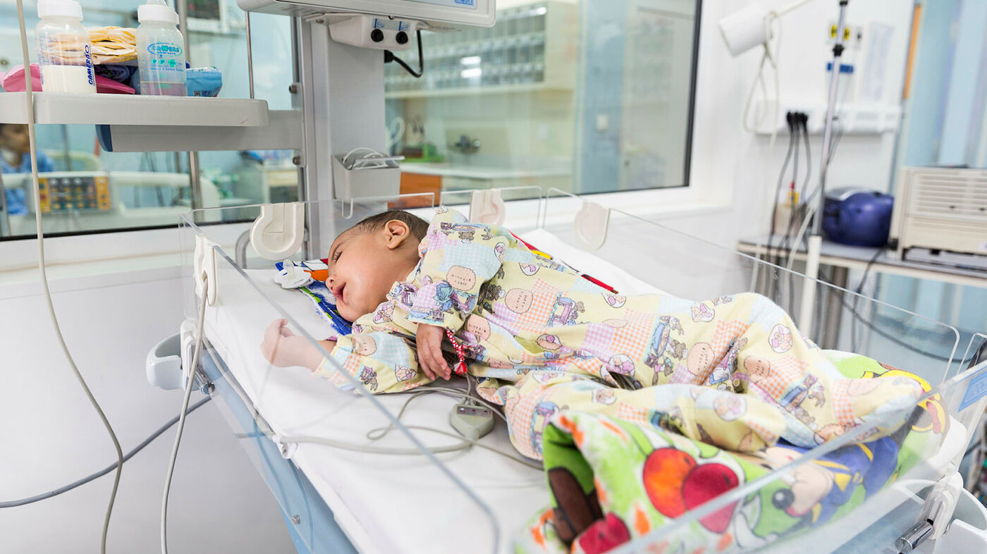 Baby på hjerteavdelingen Bildet viser en baby med hjertefeil som ligger i kuvøse på sykehus