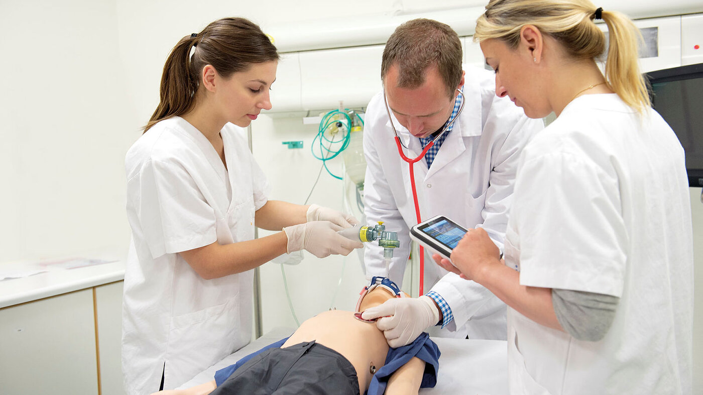 Bildet viser sykepleiere som øver på hjerte-lunge-redning med en SimPad og en førstehjelpsdukke.