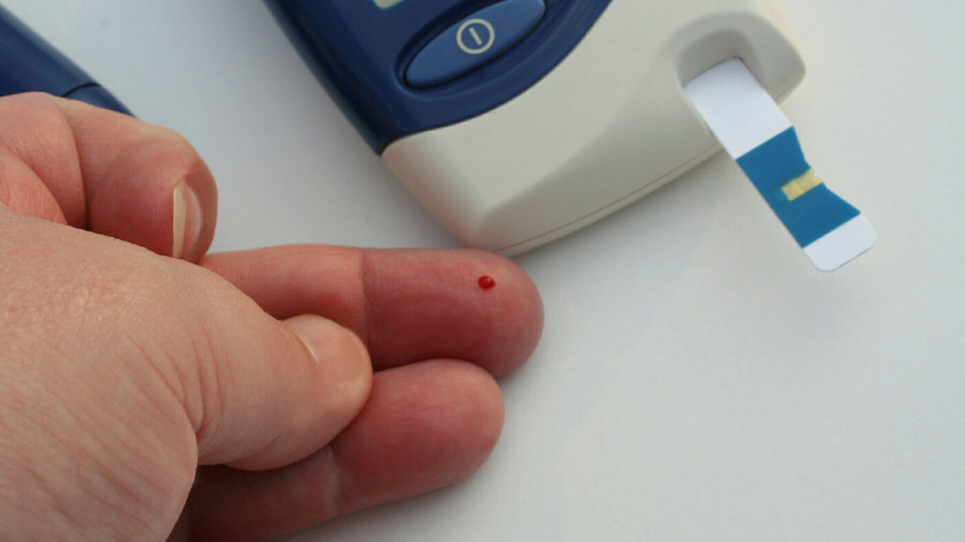 Diabetes Viser en blodprøvestikk for å måle glukoseinnhold i blodet