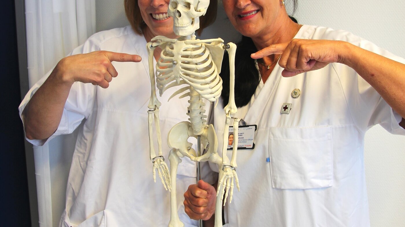Bildet viser Hanne Louise Hoelstad og May-Britt Stenbro som holder et skjelett.