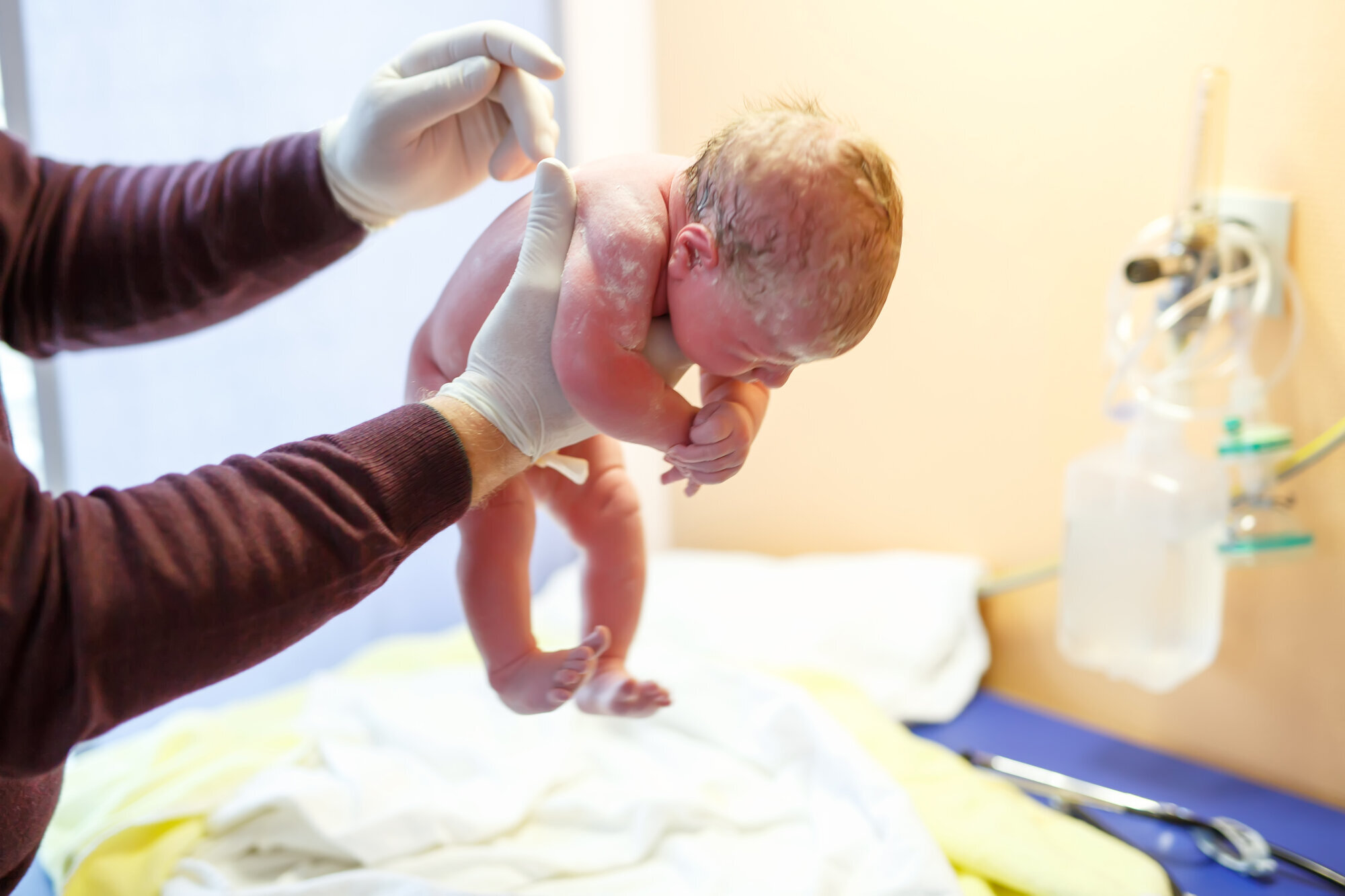 Nyfødt baby kort tid etter fødselen Bildet viser en nyfødt baby som løftes opp kort tid etter fødselen