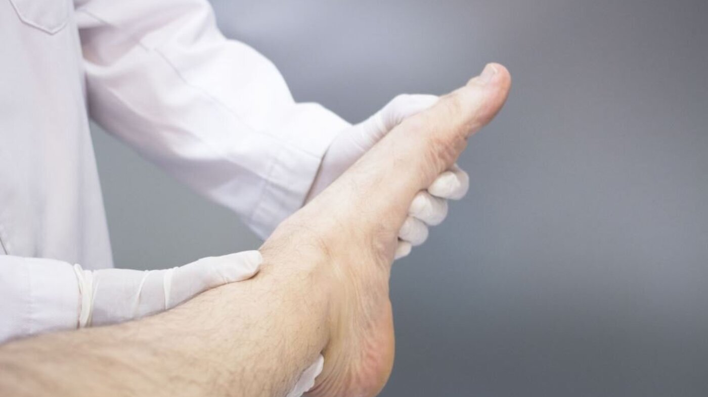 Viser ortoped som undersøker en pasients fot