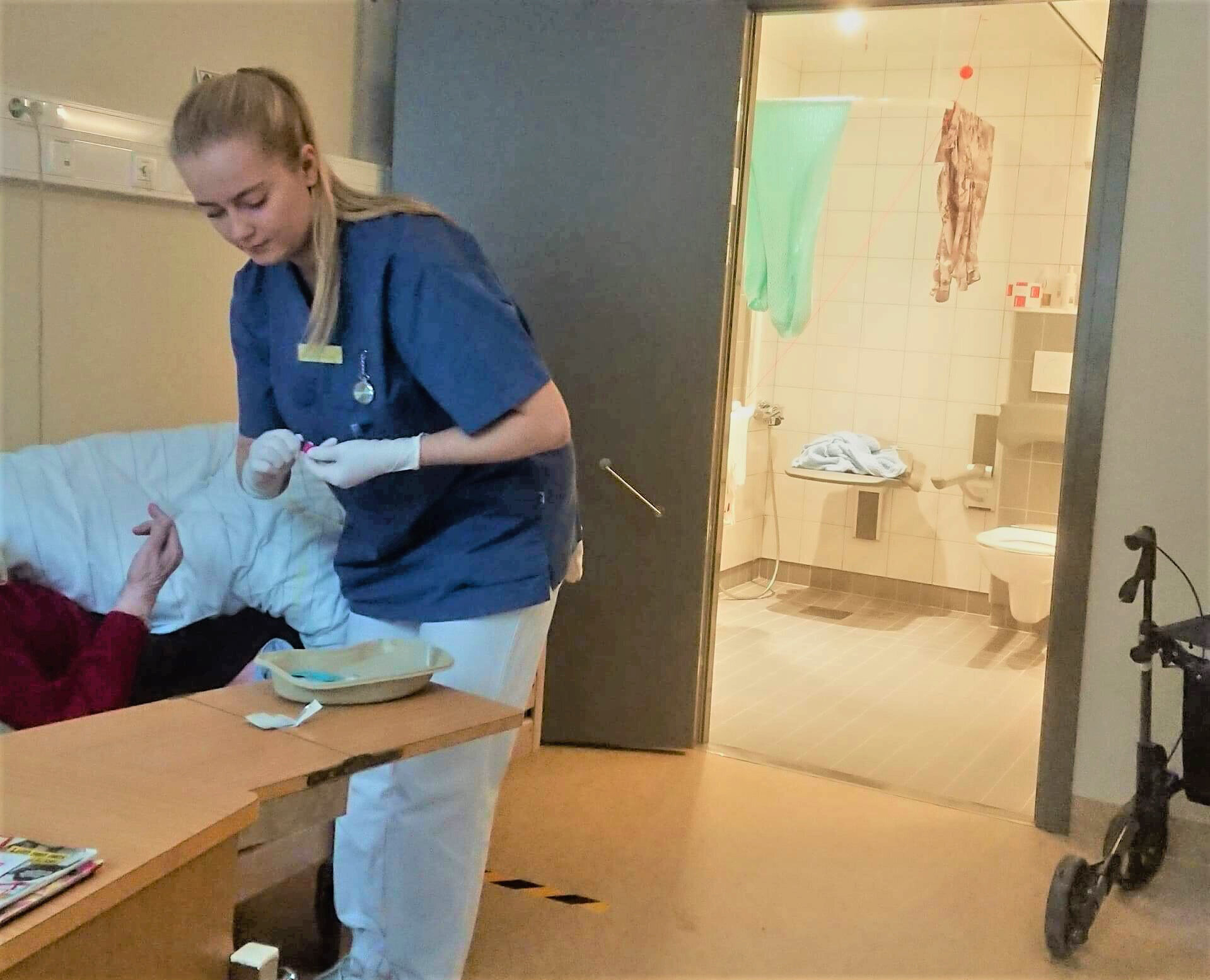 Sykepleierstudent Stine Sundberg på jobb på et eldrehjem. Bildet viser sykepleierstudent Stine Sundberg som har praksisplass på et eldrehjem. Hun hjelper en sengeliggende beboer.
