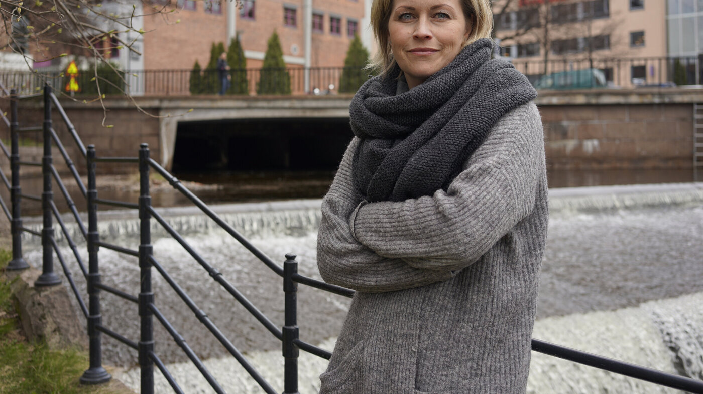 Ung kvinnelig politiker i ullgenser ved gammelt rekkverk i Oslo 