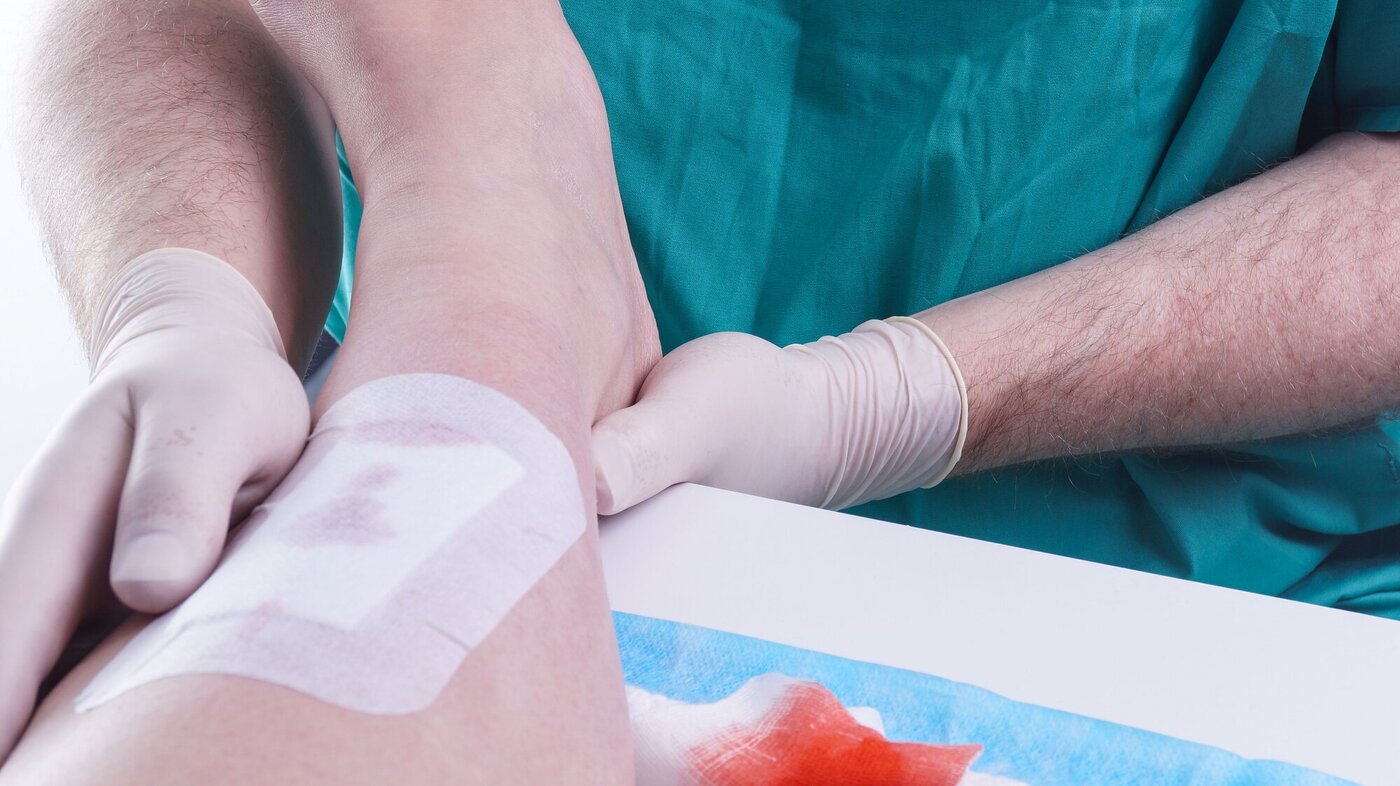 Viser helsepersonell som legger bandasje på en skadet fot