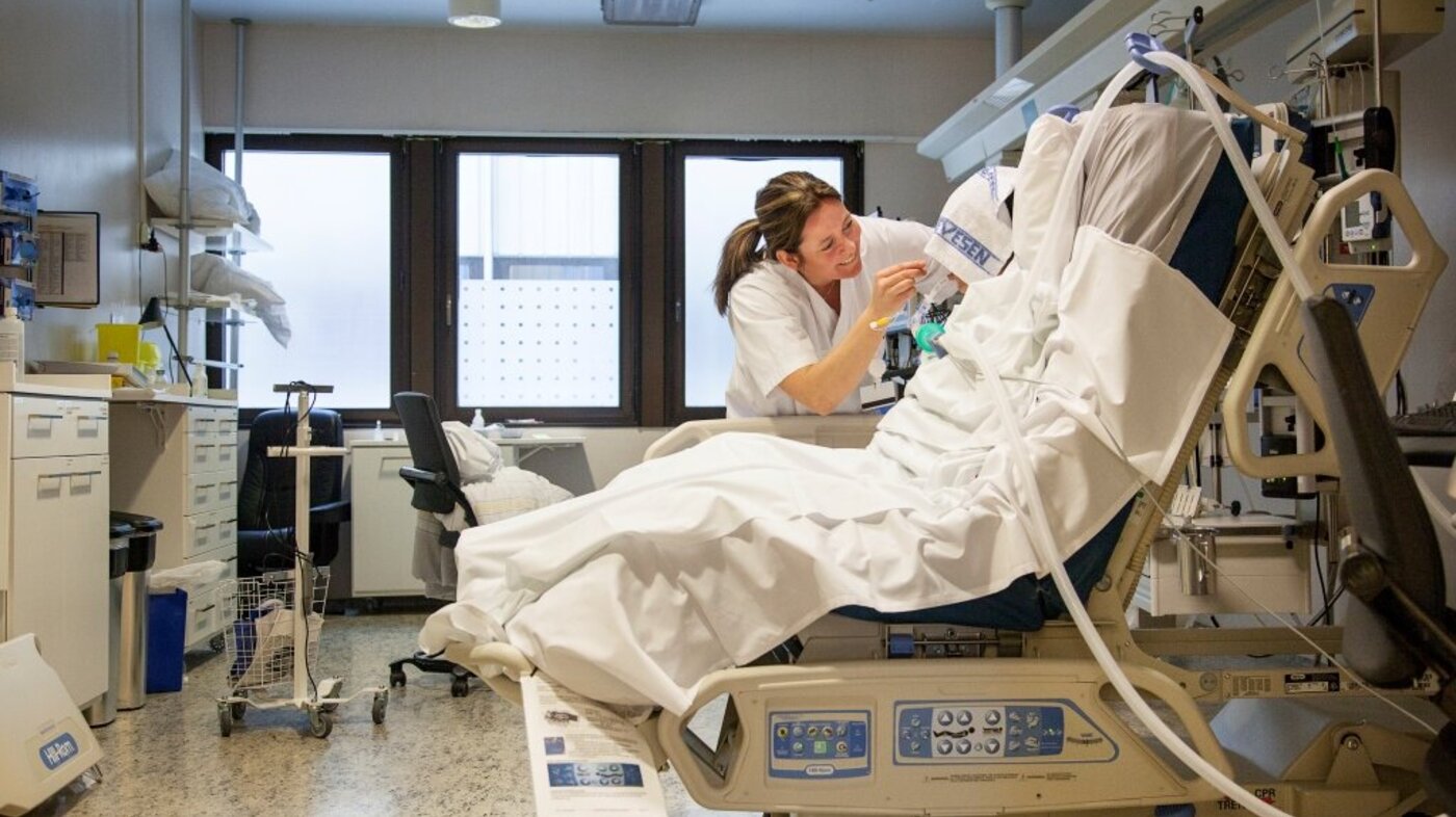 Bildet viser intensivsykepleier Grethe Teigen som steller en pasient i spesialseng.