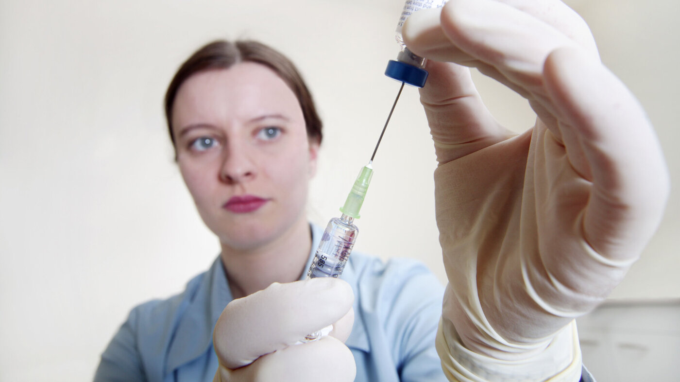 Bildet viser en sykepleier som trekker opp MMR-vaksine.