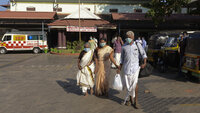 Bildet viser mennesker med munnbind utenfor et sykehus i Inda.
