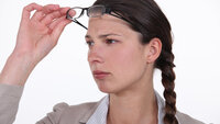 Kvinne løfter briller for å se bedre