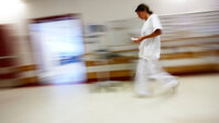 Bildet viser en sykepleier i en korridor.