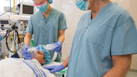 Bildet viser sykepleiere som forbereder en pasient for operasjon