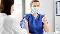 Bildet viser et helsepersonell som mottar en vaksine